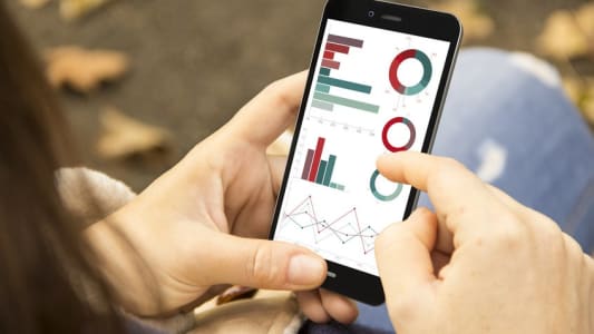 Une femme surfe sur une application mobile bancaire dans un parc