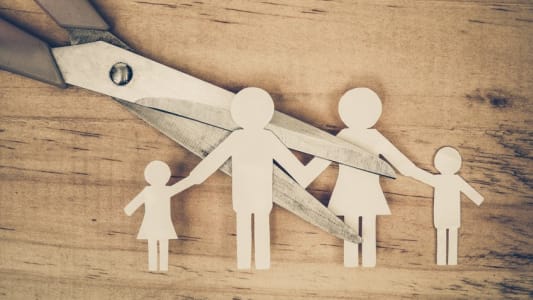 Ciseaux coupant en deux une famille de papier