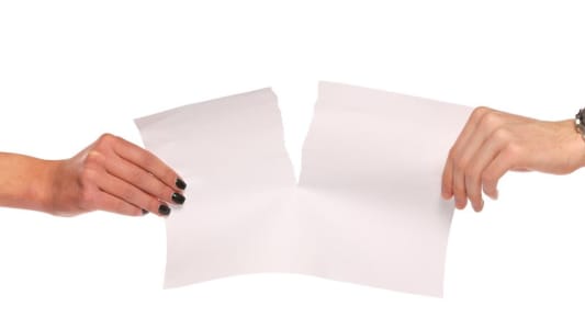 Un homme et une femme se dispute une feuille de papier déchirée
