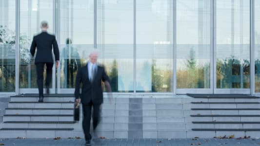 businessmen sortant et entrant dans un btiment