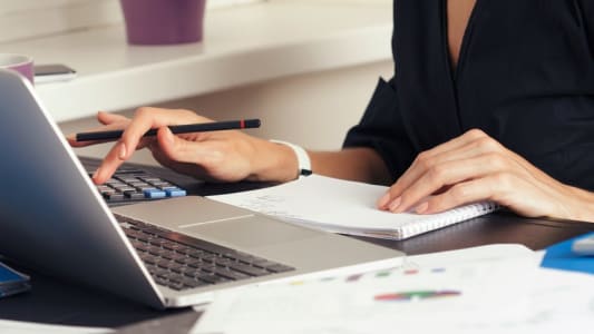 Gros plan d'une banquire faisant des calculs