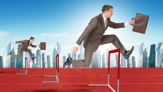 Hommes d'affaires franchissant des haies d'athlétisme