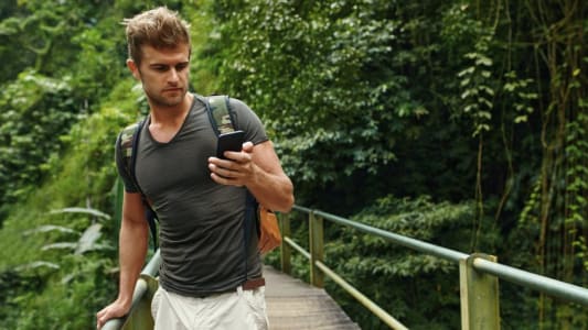 Homme utilisant son mobile lors d'une balade en fort