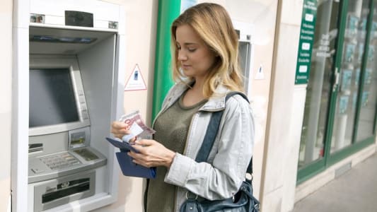 Une femme au distributeur de billets