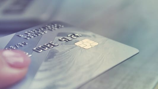 Femme tendant une carte bancaire