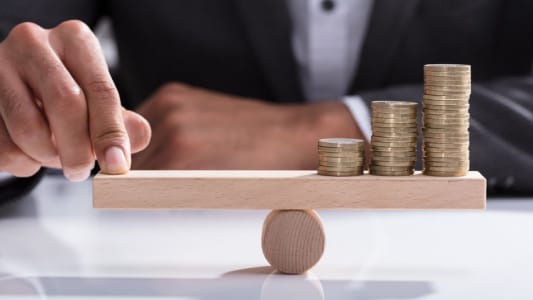 Homme d'affaires quilibrant une balance en bois