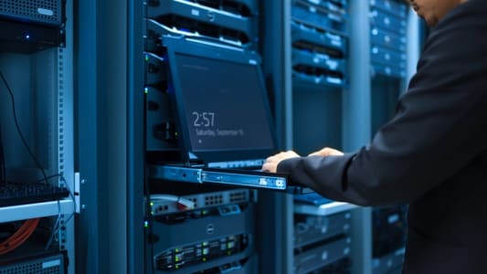 Homme intervenant sur des serveurs informatiques