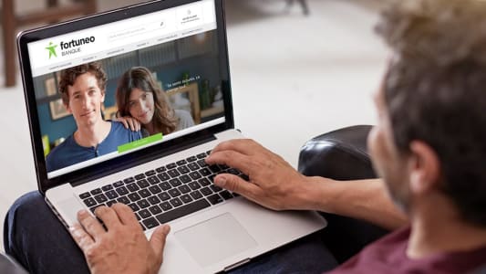 Un homme consulte le site web de Fortuneo