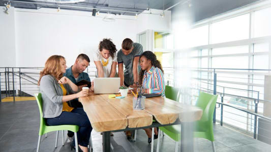Groupe de personnes au travail devant un ordinateur
