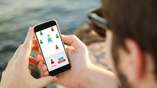 Homme utilisant son mobile pour diviser une dépense entre ses amis