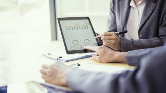 Personnes analysant un graphique sur tablette