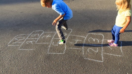 Enfants jouant  la marelle dans une cour d'cole