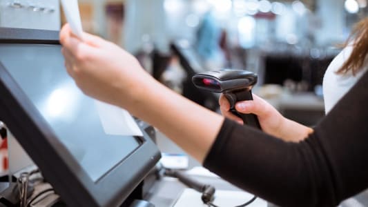 Femme scannant un article  un caisse automatique