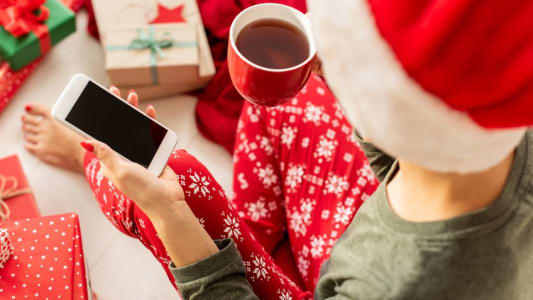 Jeune femme en bonnet de Nol consultant son smarphone