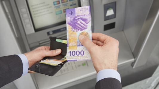 Retrait au distributeur d'un billet de 1000 francs suisses