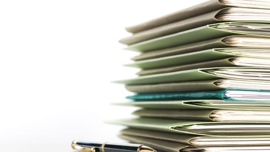 Un stylo  ct d'une pile de dossiers