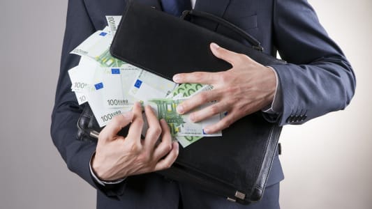 Une homme et une valise pleine de billets