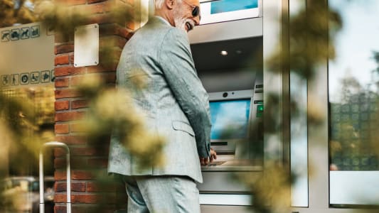 Senior qui retire de l'argent dans un distributeur