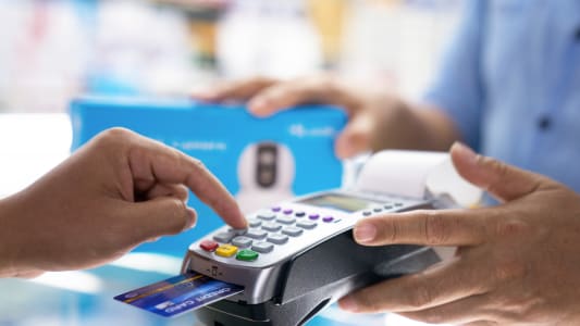 Consommateur tapant son code de carte bancaire