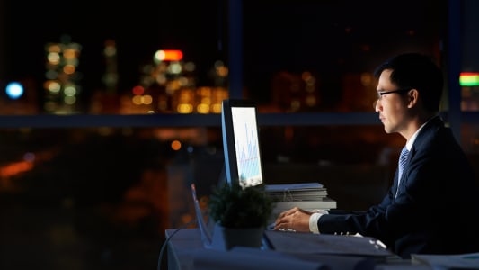 Homme en costume dans l'obscurit devant un cran d'ordinateur