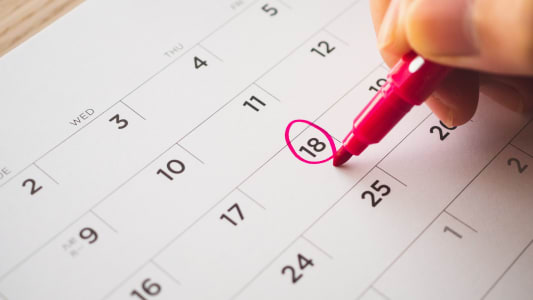 personne qui entoure une date dans un calendrier