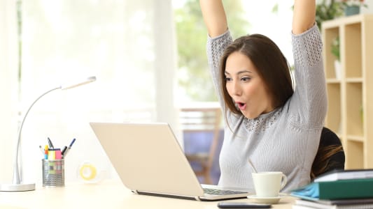 Femme heureuse devant son ordinateur