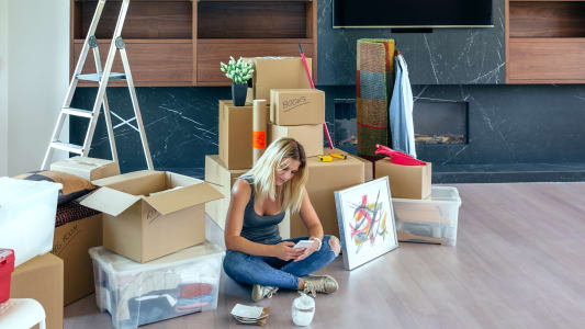 Femme consultant son smartphone pendant un dmnagement