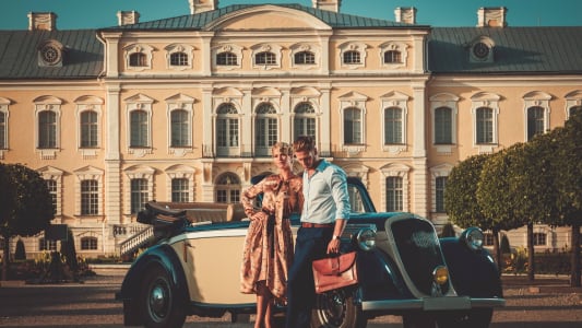 Couple aisé devant une demeure