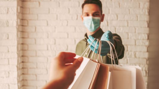 Un homme masqu dlivre des sacs de courses  une femme