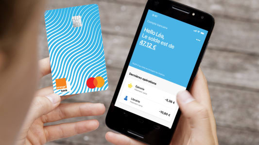 Une adolescente consulte son compte Orange Bank sur son mobile