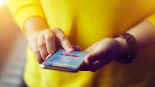 Une femme se connecte à l'application mobile de sa banque
