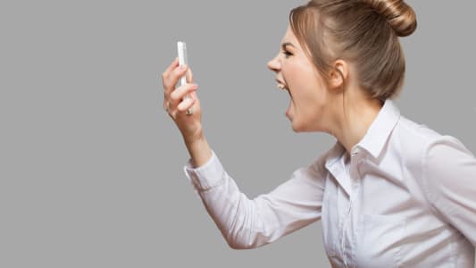 Une femme crie face à son téléphone