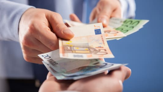 Deux hommes échangent des billets en euros