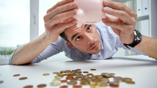 Un homme dans un bureau vide sa tirelire
