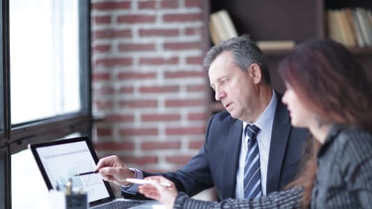 Un homme et une femme collaborent face  un ordinateur