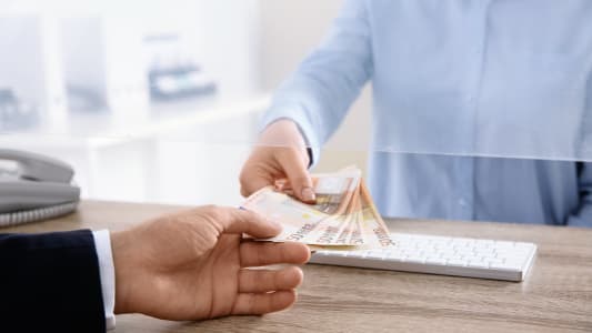 Un homme reçoit de l'argent à un guichet