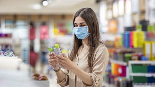 Une jeune femme en train de faire des courses en supermarch