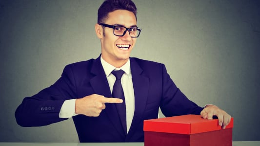 un homme pointant du doigt un cadeau