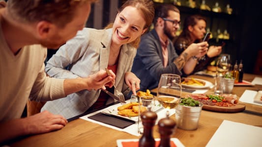 Une jeune femme au restaurant avec des amis
