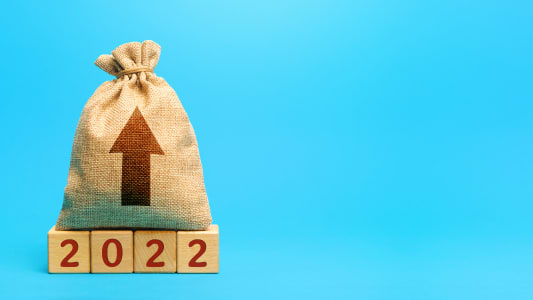 Sac d'argent imprim d'un flche vers le haut pos sur des cubes en bois indiquant 2022