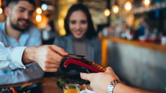 Un couple au restaurant paie sans contact par carte bancaire