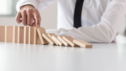 Un homme empêche des dominos de chuter