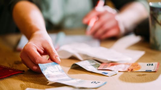 Une femme fait ses comptes et manipule des billets