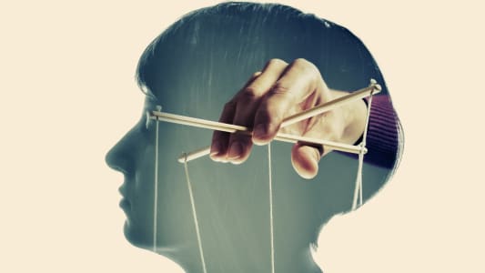 Image d'une main manipulant l'esprit d'une personne