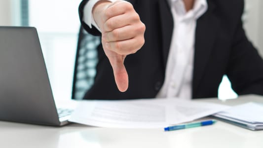 Un homme pointe son pouce vers le bas