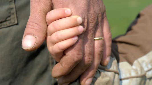 homme tenant fils par la main