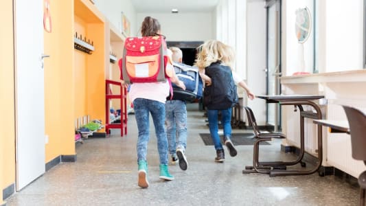 Enfants courant dans le couloir d'une cole.