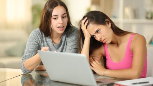 Deux jeunes femmes devant un ordinateur.