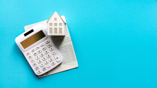 Une maison, des documents et une calculatrice