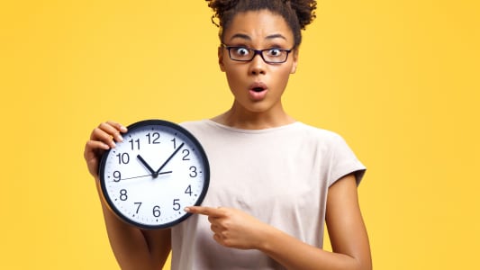 Une femme tient une horloge.